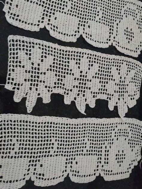 Three Pieces Of White Crocheted Lace On Black Fabric With Holes In The