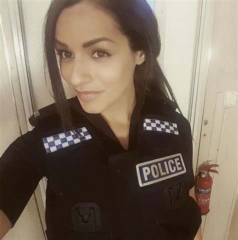 A Woman In A Police Uniform Taking A Selfie