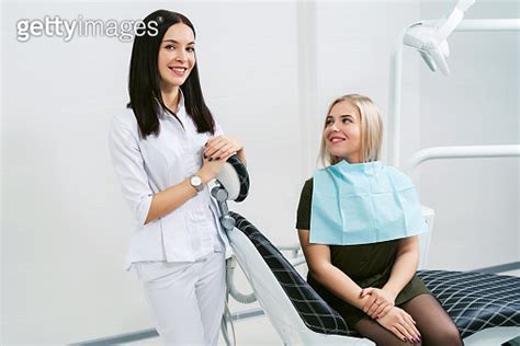 Portrait Of A Friendly Smiling Female Dentist With Happy Patient In The