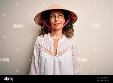 Middle Age Brunette Woman Wearing Asian Traditional Conical Hat Over White Background Smiling
