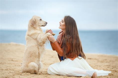 Retrato De Una Mujer Joven Con Un Perro En La Playa Foto De Archivo