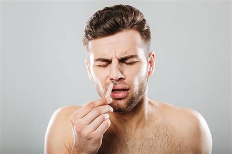 Free Photo Man In Pain Removing Nose Hair With Tweezers