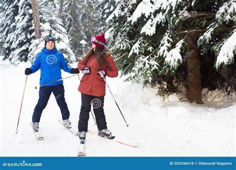 Happy Married Couple Skiing At A Ski Resort In The Forest Stock Photo