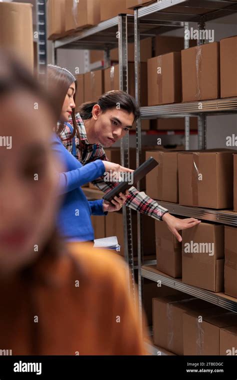 Warehouse Employees Inspecting Parcels On Rack And Doing Inventory