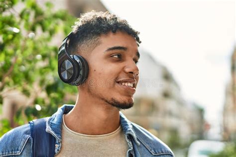 Hispanic Young Man Listening To Music Wearing Headphones At The Street