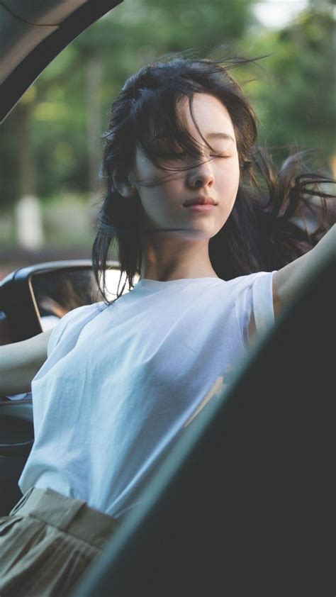 A Woman Is Sitting In The Back Seat Of A Car With Her Eyes Closed And