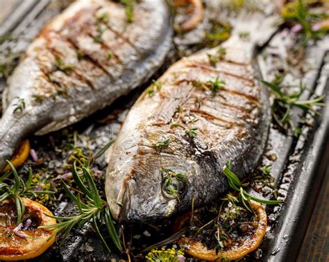 Grilled Fish With Herbs And Lemon On A Grill Plate Close Up View