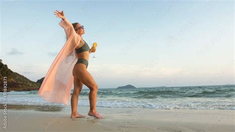 Sexy Hot Woman Walks On Golden Sunset On Tropical Beach Wet Sand Against Background Of Sea