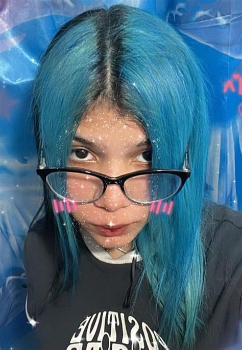 A Woman With Blue Hair And Glasses On Her Face