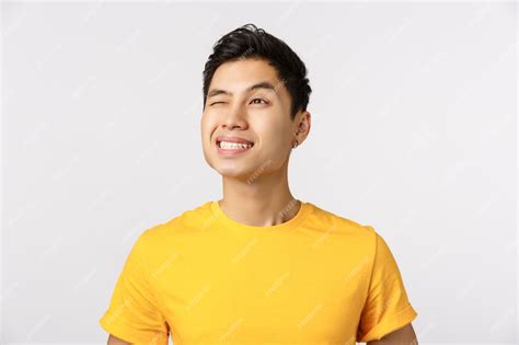 Premium Photo Cute Asian Man In Yellow T Shirt Smiling And Winking