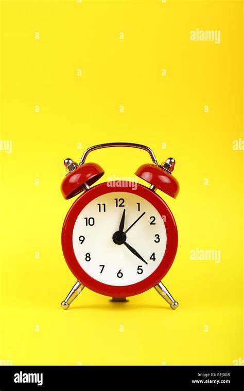 Close Up One Small Red Metal Twin Bell Retro Alarm Clock Over Yellow
