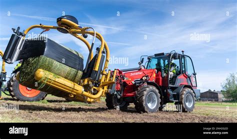 Wrapping Big Bales Of Silage With An Attachment On The Front Of A