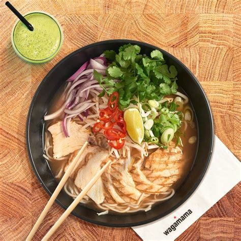 A Bowl Filled With Meat And Veggies Next To A Cup Of Green Juice