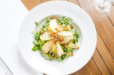 Premium Photo Arugula Salad With Pear Slices And Gorgonzola Crumble