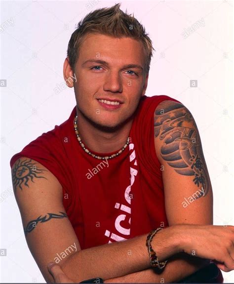 a man in a red shirt with tattoos on his arms