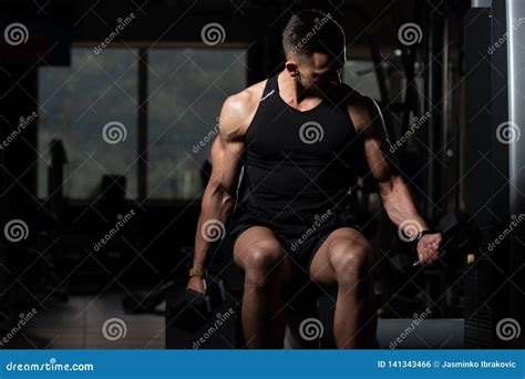 Hombre Muscular Que Ejercita El B Ceps Con Pesa De Gimnasia Foto De