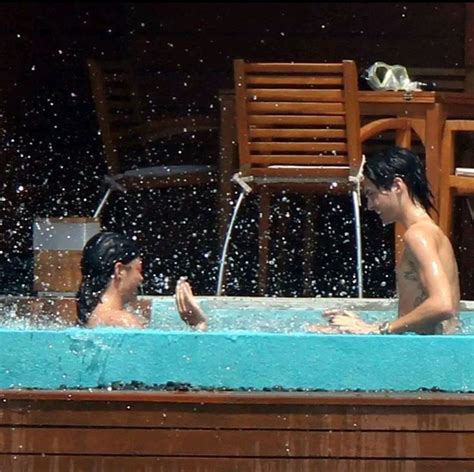 Two People In A Hot Tub With Water Splashing All Over The Sides And Back