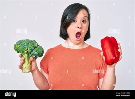 Brunette Woman With Down Syndrome Holding Broccoli And Red Pepper