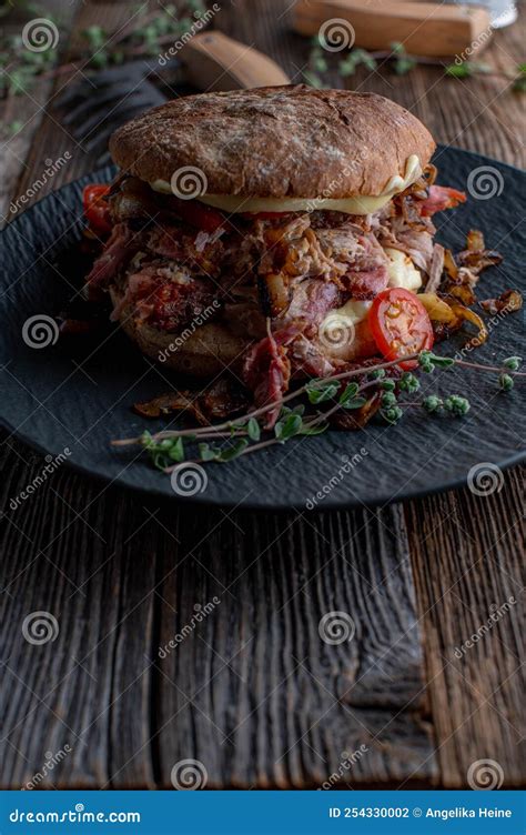 Pulled Pork Burger With Roasted Onions Cheese Pickles And Tomatoes On