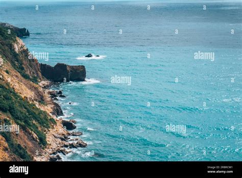 The Azure Sea Against The Backdrop Of Mountains And Green Trees Stock