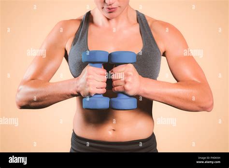 Composite Image Of Muscular Woman Lifting Heavy Dumbbells Stock Photo