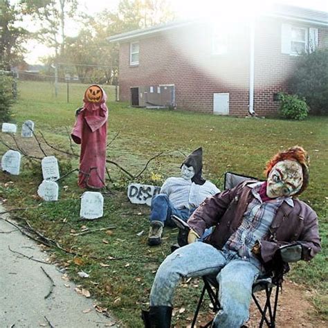 Two Scarecrows Are Sitting In Lawn Chairs With Heads On Them And