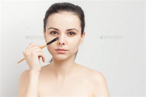 Pretty Brunette Naked Shoulders Brush In Hand Applying Makeup Stock