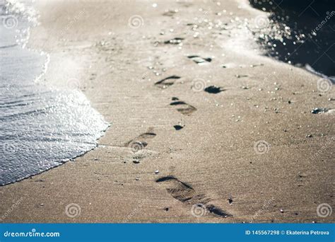 Footprints In The Sand By The Sea Sea Wave On The Sandy Shore Next To