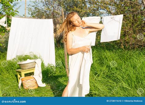 Beautiful Red Girl In Nightie Hanging Laundry Outdoors Village Woman