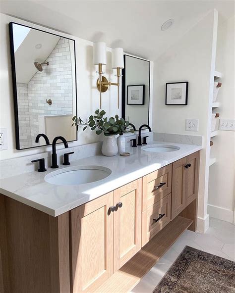 A Bathroom With Double Sinks And Mirrors On The Wall Above Them Is