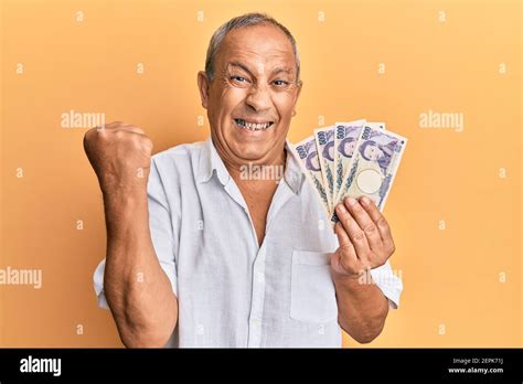 Handsome Mature Man Holding Japanese Yen Banknotes Screaming Proud