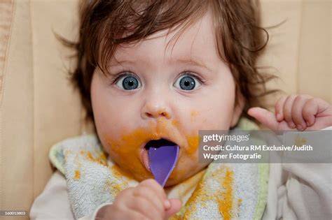 Surprised Baby Eating Messy Food High Res Stock Photo Getty Images