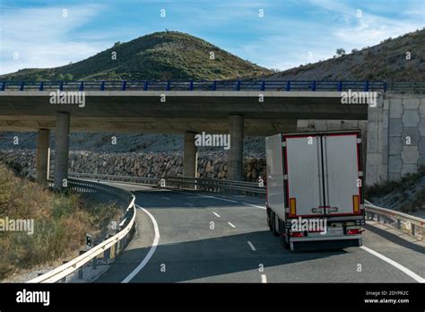 Camión con semirremolque blanco refrigerado que conduce a través de un