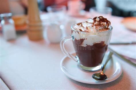 Hot Chocolate With Whipped Cream And Cocoa Powder On A Table In A Cafe