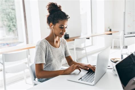 Femme Africaine Romantique Avec Une Coiffure à La Mode Assise Sur Son Lieu De Travail Et Analyse