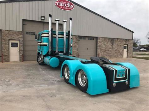 a large blue semi truck parked in front of a building