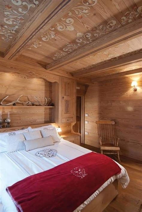 A Bedroom With Wood Paneled Walls And White Bedding Along With A Red