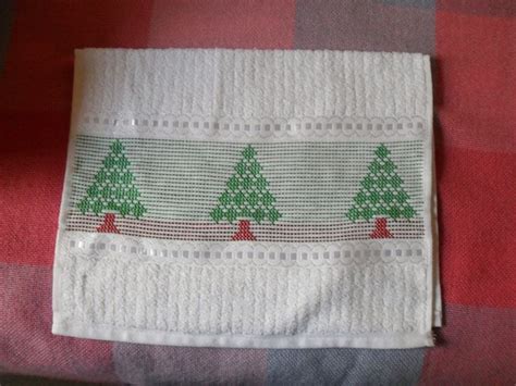 Two White Towels With Christmas Trees On Them Are Sitting On A Red