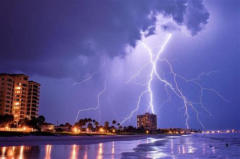 Premium Photo | A lightning storm over a beach with buildings in the ...