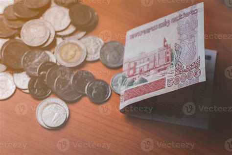 Closeup Shot Of Lao KIP Currency And Thai Baht Coin Exchange And