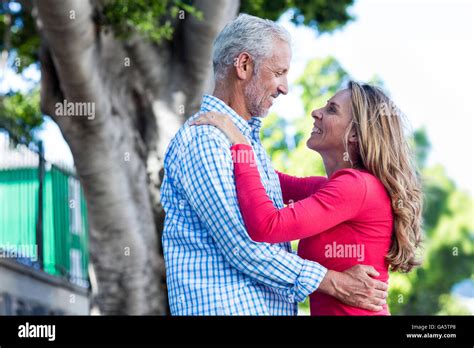Romantic Mature Couple Hugging Against Tree Stock Photo Alamy