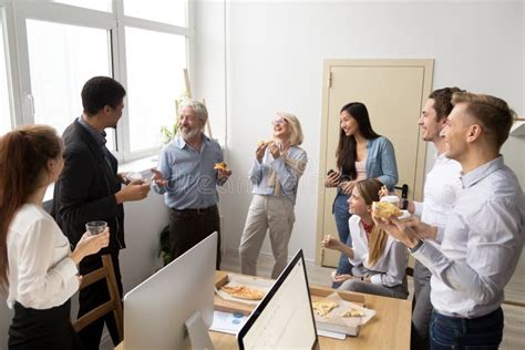 Friendly Diverse Business Team Talking And Laughing Eating Pizza Stock