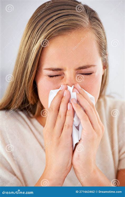 Shes Getting The Sniffles A Young Woman Blowing Her Nose Into A Tissue