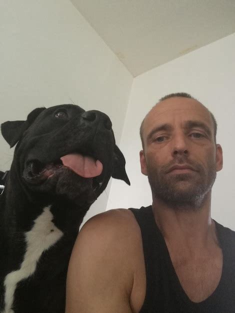 Premium Photo Low Angle Portrait Of Man With Black Dog At Home