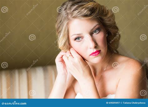 Beautiful Elegant Bride Putting On Earrings Closeup Wedding