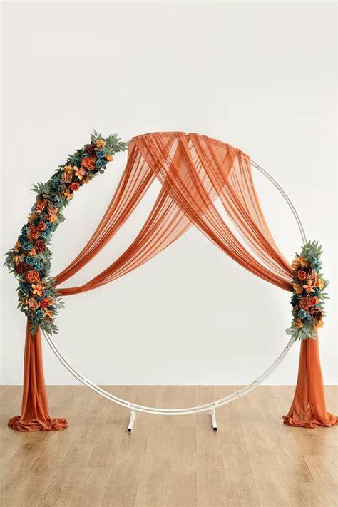 An Orange And White Wedding Arch Decorated With Flowers Greenery And