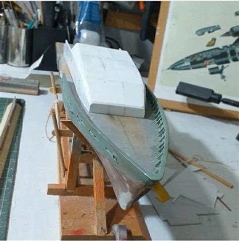 A Model Boat Sitting On Top Of A Wooden Table Next To Some Wood Planks