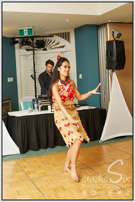 a woman in a red and gold dress on a dance floor with a man behind her