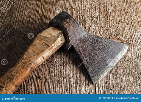 The Head Of An Old Axe With A Wooden Handle On A Background Of Rough