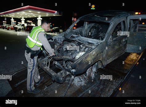 A California Highway Patrol Officer Examines One Of 30 Cars Destroyed